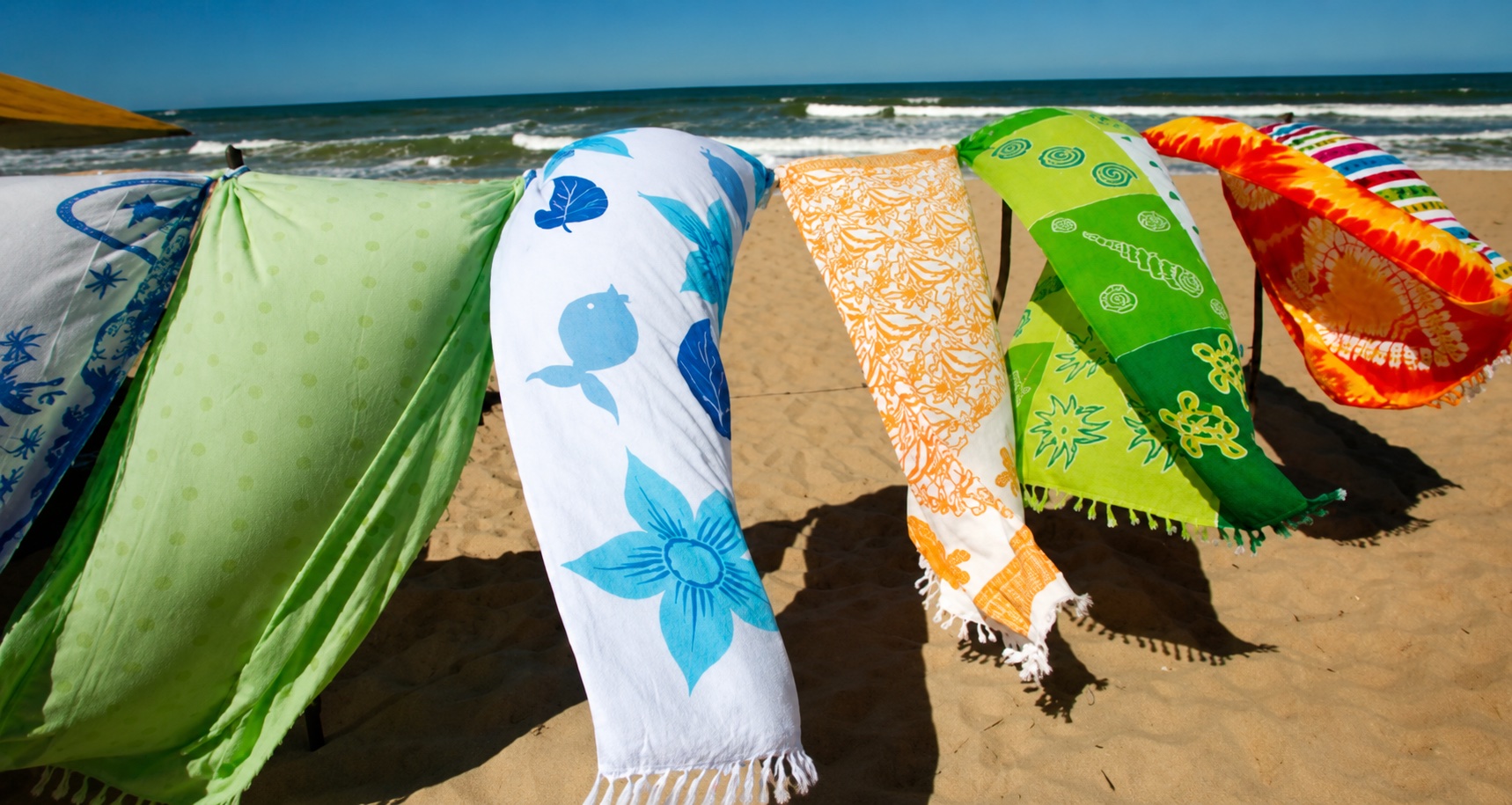Colorful cotton beach towels hanging by the sea