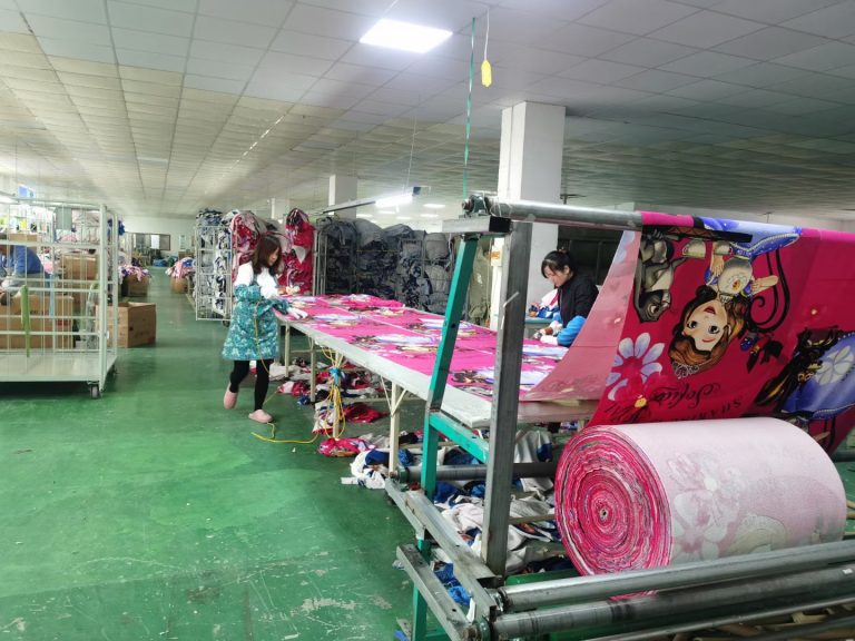 Worker cutting microfiber towel fabric to size