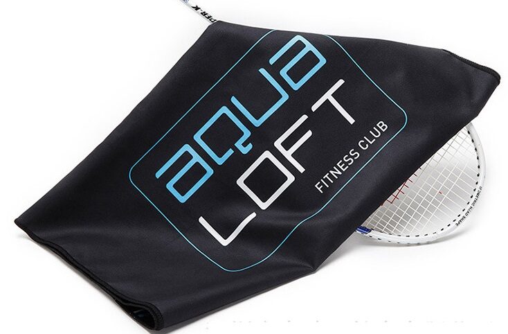 Black custom printed fitness towel displayed over a racket on a white background