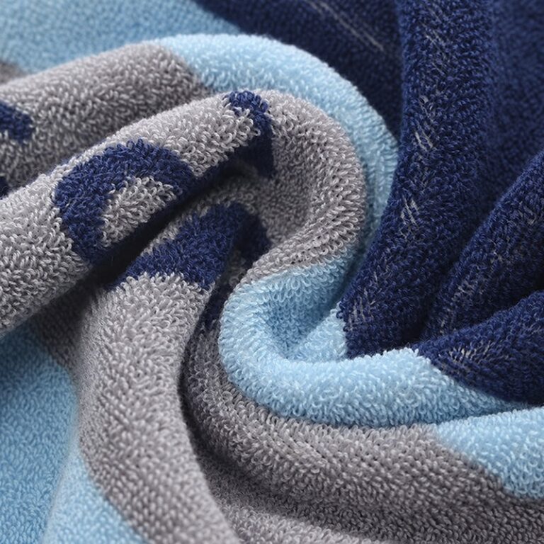 Blue gray and navy cotton terry fabric showing woven motifs and cotton loops