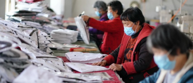 Workers checking and packing finished textile products