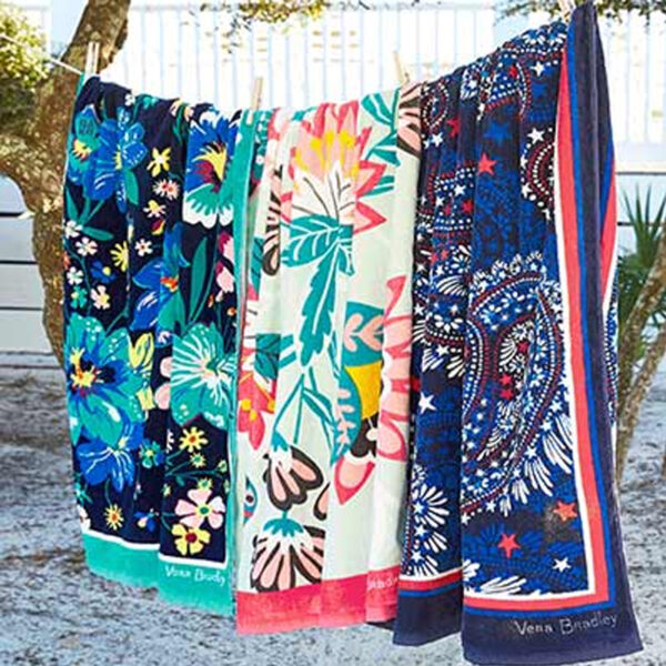 Three colorful printed cotton beach towels hanging outdoors