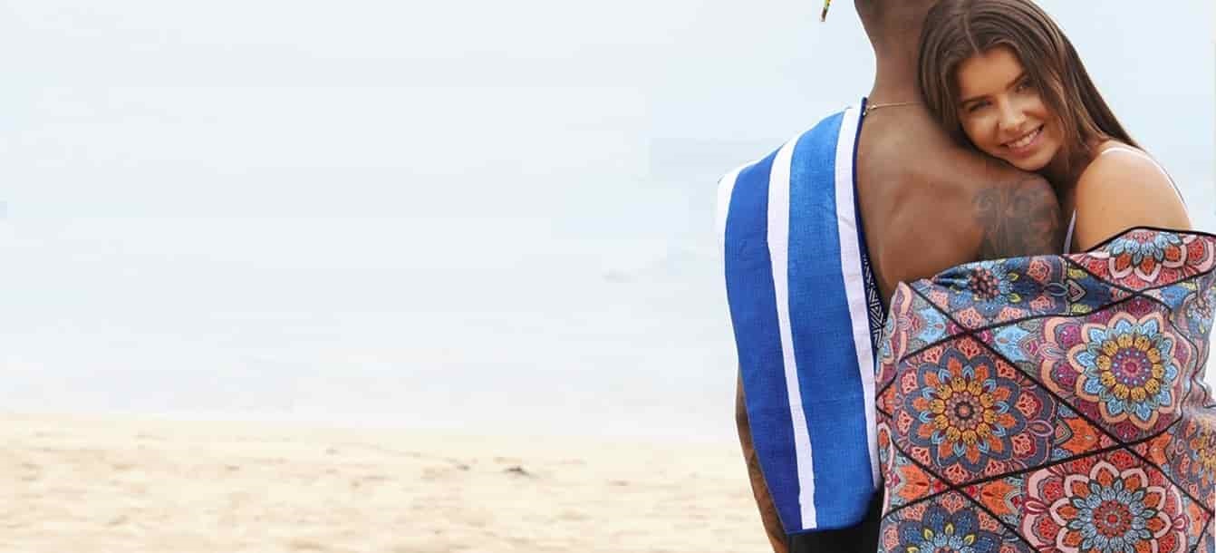 Beachgoers with blue striped and colorful printed sand-free beach towels
