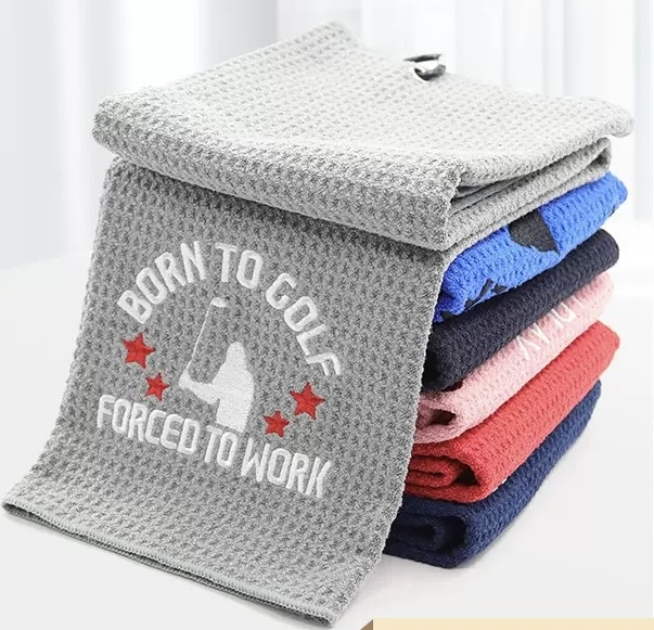 Stack of textured sports towels with a stitched logo on the gray towel