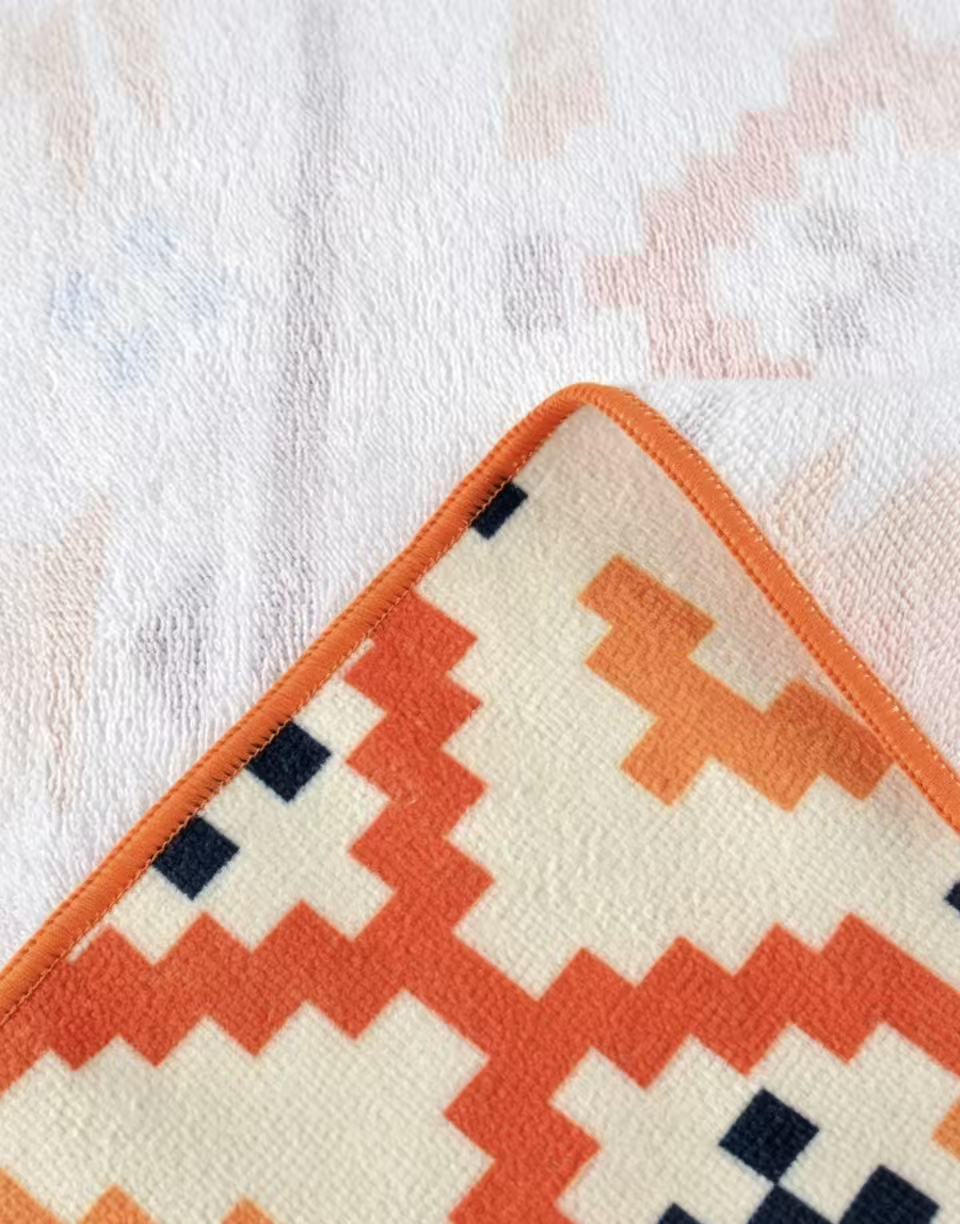 Close-up of orange patterned microfiber velour towel with terry back side