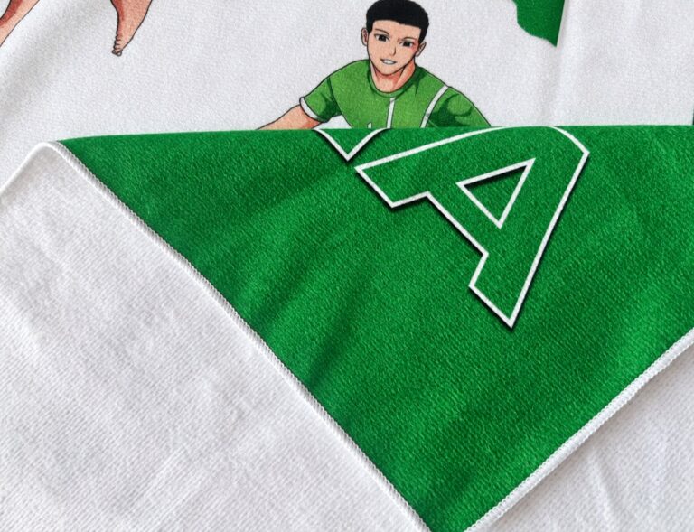 Green printed microfiber brushed towel with white reverse, stitched edge and upright character artwork