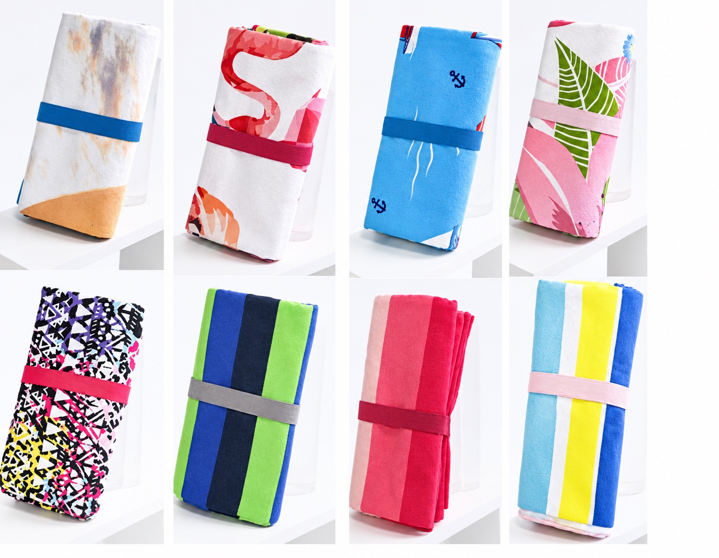 Eight folded beach towels in different custom patterns and colors